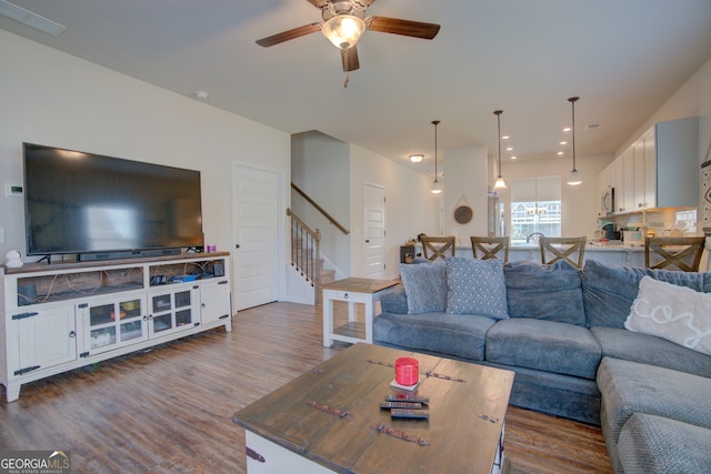 living room with dark wood-type flooring and ceiling fan