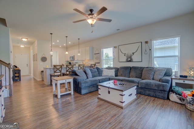 living room with ceiling fan and light wood-type flooring