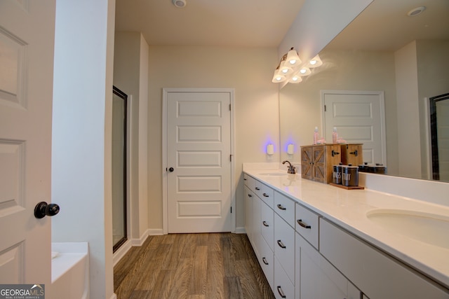 bathroom with vanity, hardwood / wood-style floors, and shower with separate bathtub