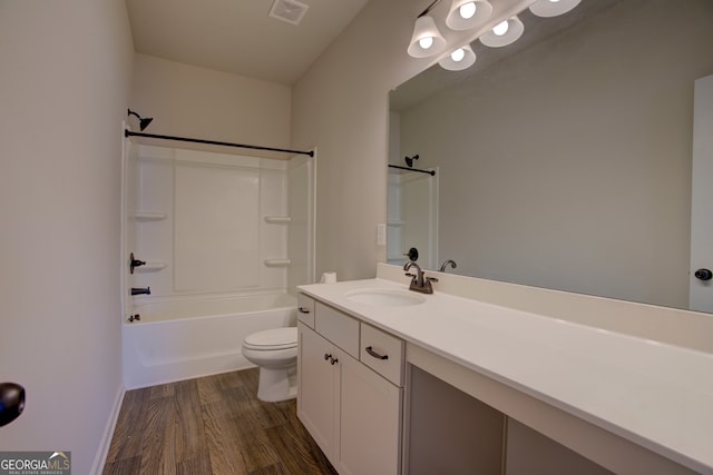 full bathroom featuring hardwood / wood-style floors, toilet,  shower combination, and vanity