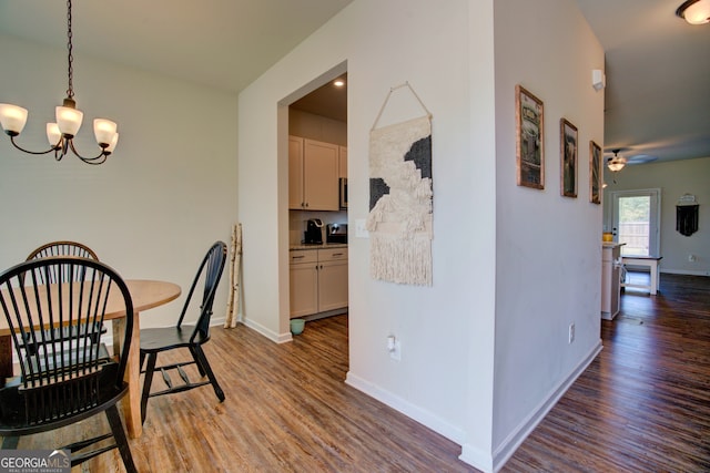 dining area featuring ceiling fan with notable chandelier and hardwood / wood-style floors