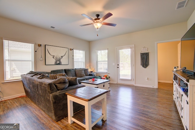 living room featuring dark wood-type flooring and ceiling fan