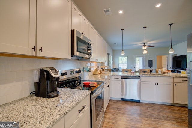 kitchen featuring white cabinets, backsplash, light wood-type flooring, stainless steel appliances, and ceiling fan