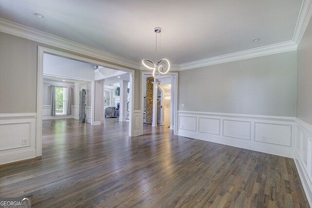 unfurnished room featuring decorative columns, dark hardwood / wood-style floors, a chandelier, and crown molding