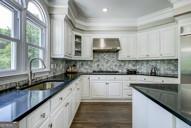 kitchen with a healthy amount of sunlight, dark hardwood / wood-style floors, wall chimney exhaust hood, and white cabinets