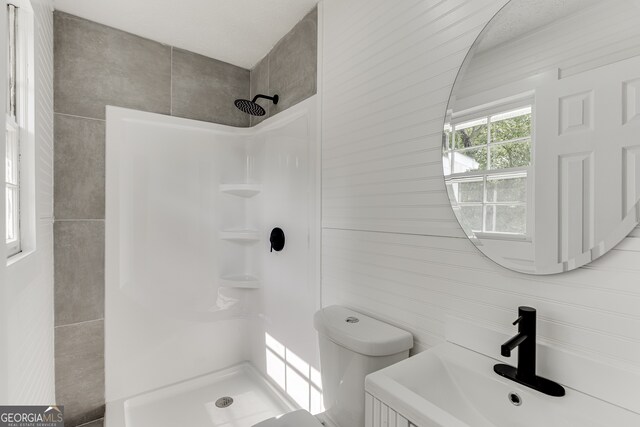 bathroom featuring a shower, toilet, and sink