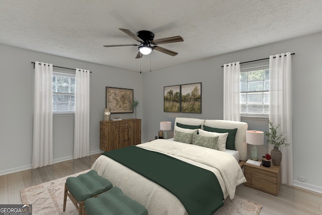 bedroom with multiple windows, ceiling fan, light hardwood / wood-style floors, and a textured ceiling