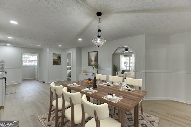 dining space with light hardwood / wood-style floors and a textured ceiling