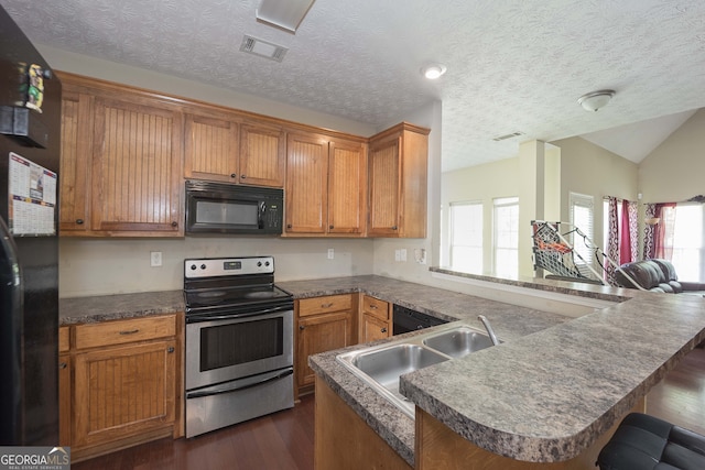 kitchen featuring a textured ceiling, black appliances, sink, dark hardwood / wood-style floors, and vaulted ceiling