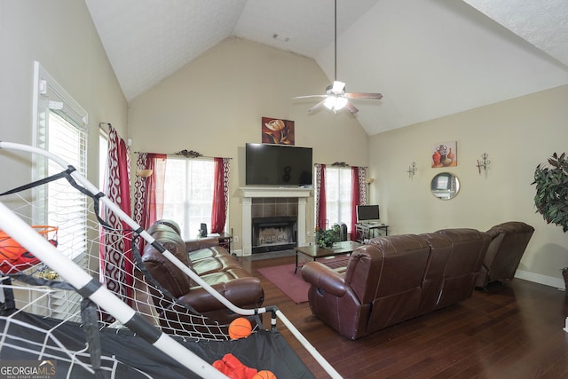 living room featuring dark wood-type flooring, ceiling fan, high vaulted ceiling, and a fireplace