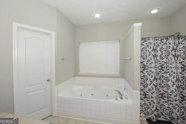 bathroom with a textured ceiling, tile patterned floors, and shower with separate bathtub