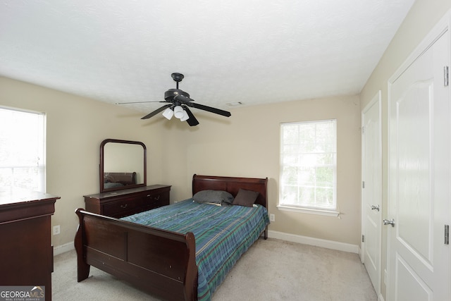 carpeted bedroom with ceiling fan and a textured ceiling