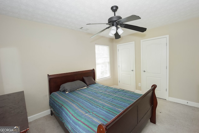 carpeted bedroom featuring a textured ceiling and ceiling fan