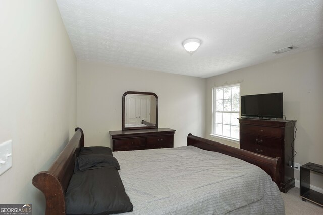 carpeted bedroom with a textured ceiling