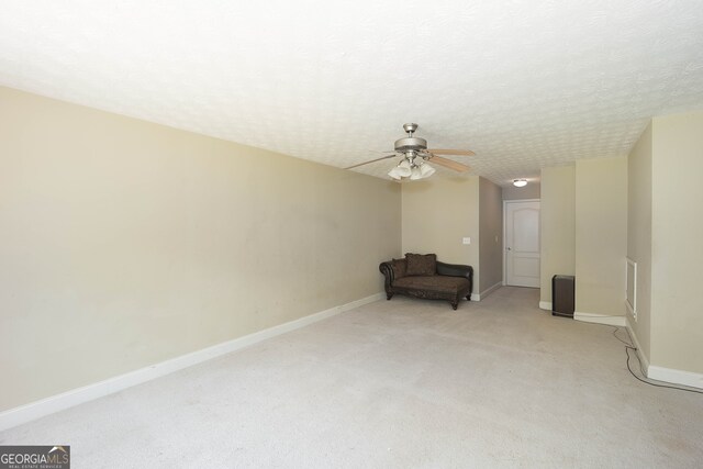 unfurnished room featuring light colored carpet, ceiling fan, and a textured ceiling