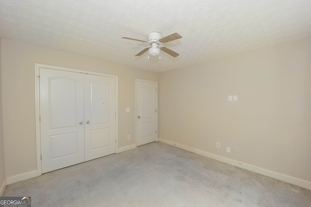 unfurnished bedroom with light carpet, a textured ceiling, and ceiling fan