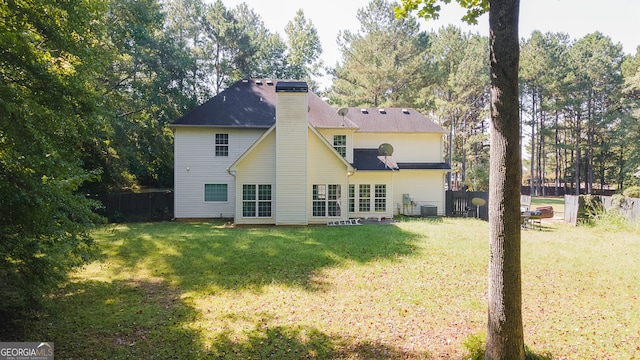 back of property with cooling unit and a lawn