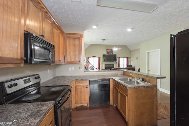 kitchen with vaulted ceiling, black appliances, dark hardwood / wood-style floors, kitchen peninsula, and a textured ceiling