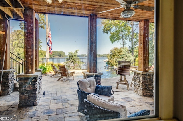 view of patio / terrace featuring ceiling fan and a water view