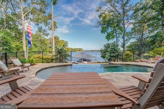 view of swimming pool with a patio area and a water view