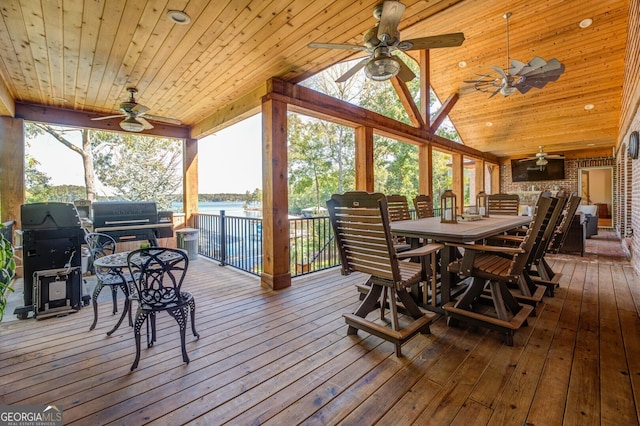 sunroom / solarium with ceiling fan, wooden ceiling, vaulted ceiling, and a water view