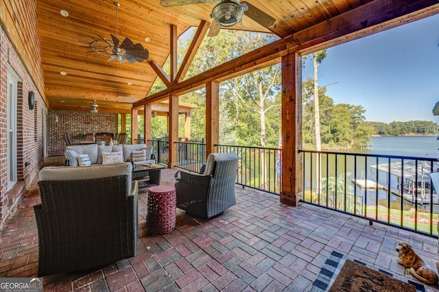 sunroom / solarium with wood ceiling, ceiling fan, vaulted ceiling, and a water view