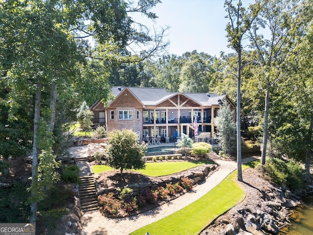 view of front of house with a front yard and a water view