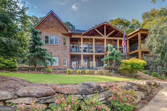 rear view of house with a yard and a balcony