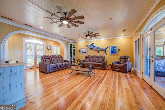 living room with light wood-type flooring, a healthy amount of sunlight, ceiling fan, and french doors