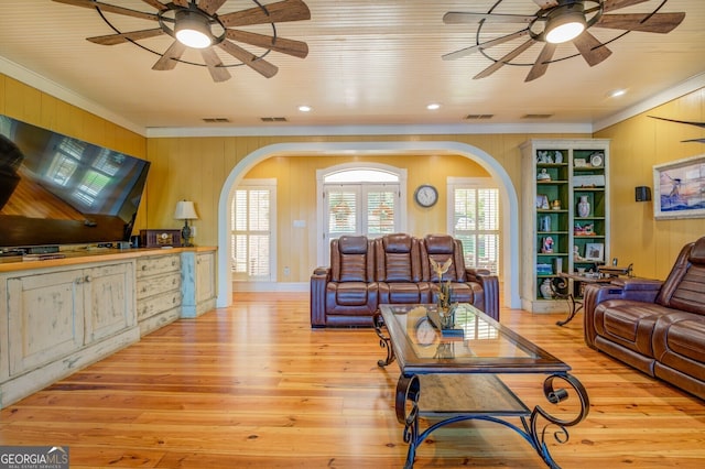 living room featuring wood walls, ceiling fan, light hardwood / wood-style floors, and ornamental molding