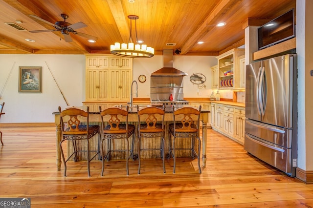 kitchen with exhaust hood, pendant lighting, light hardwood / wood-style floors, stainless steel refrigerator, and ceiling fan