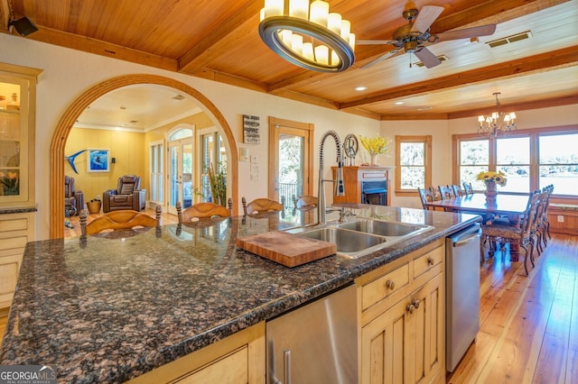 kitchen featuring light wood-type flooring, ceiling fan with notable chandelier, dishwasher, and beam ceiling