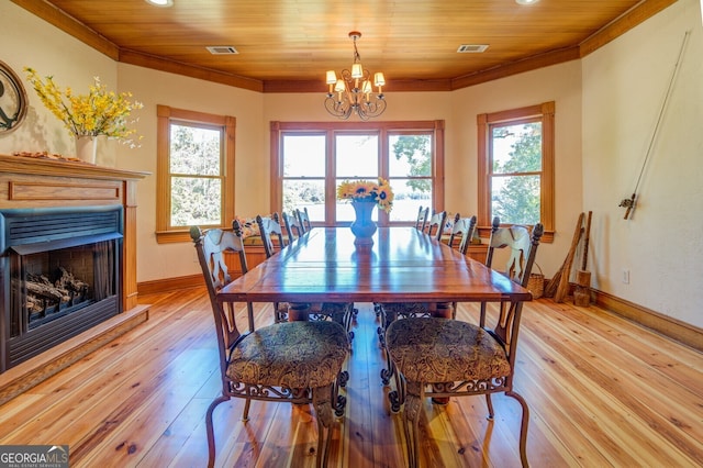 dining space with light wood-type flooring, an inviting chandelier, and a healthy amount of sunlight