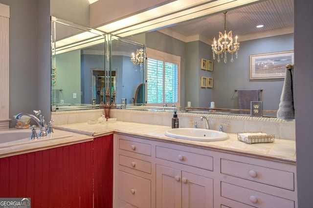 bathroom with ornamental molding, an inviting chandelier, and vanity