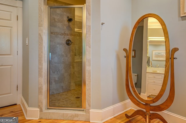 bathroom featuring a shower with door, hardwood / wood-style flooring, and vanity