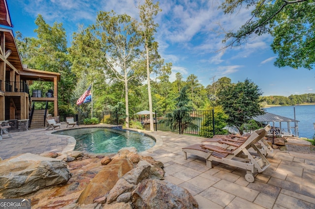 view of swimming pool featuring a patio and a water view