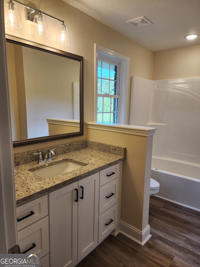 bathroom with vanity, toilet, and hardwood / wood-style flooring