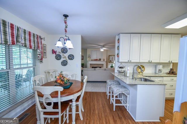 dining area with dark wood-type flooring, ceiling fan, and sink