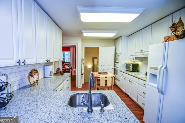 kitchen featuring white refrigerator with ice dispenser, sink, dark hardwood / wood-style floors, and white cabinets