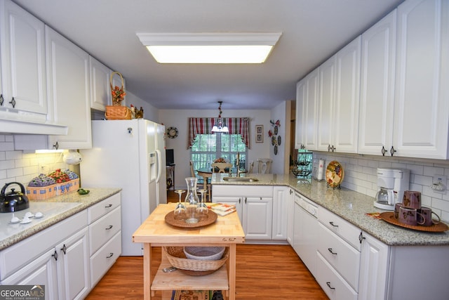 kitchen with white appliances, light hardwood / wood-style flooring, kitchen peninsula, sink, and white cabinets