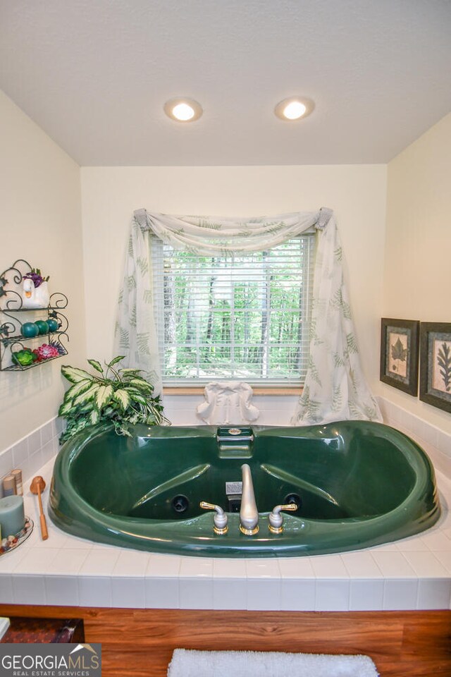 bathroom featuring a relaxing tiled tub