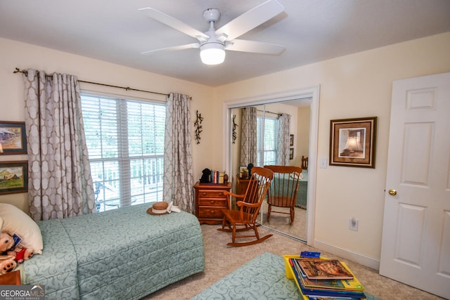 carpeted bedroom featuring multiple windows, ceiling fan, and a closet