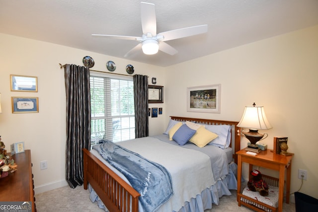 bedroom featuring a textured ceiling, ceiling fan, and light carpet