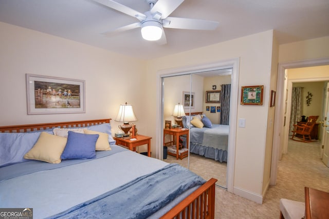 bedroom with light colored carpet, ceiling fan, and a closet