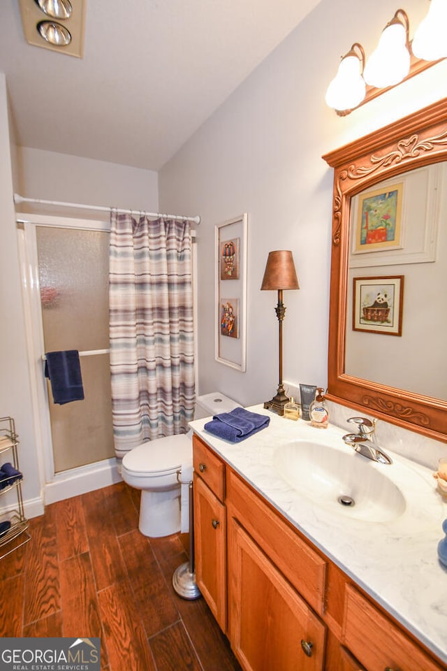 bathroom featuring vanity, toilet, a shower with curtain, and hardwood / wood-style flooring