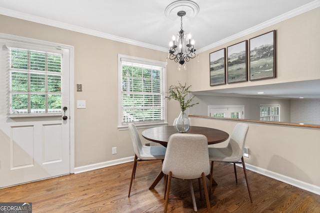 dining space featuring crown molding, a notable chandelier, and hardwood / wood-style flooring