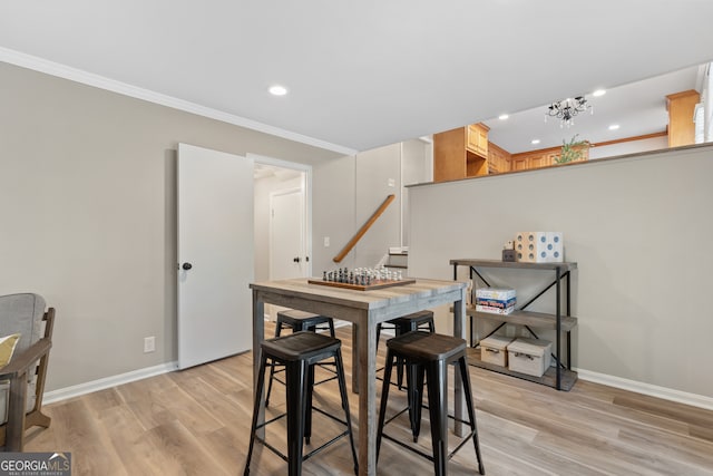 dining room with light hardwood / wood-style floors and ornamental molding