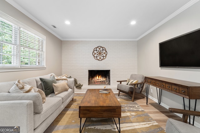 living room with a fireplace, ornamental molding, and hardwood / wood-style floors