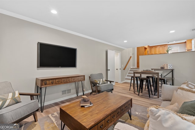 living room featuring light wood-type flooring and ornamental molding