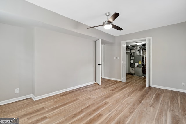 unfurnished bedroom featuring light hardwood / wood-style flooring, ceiling fan, a walk in closet, and a closet